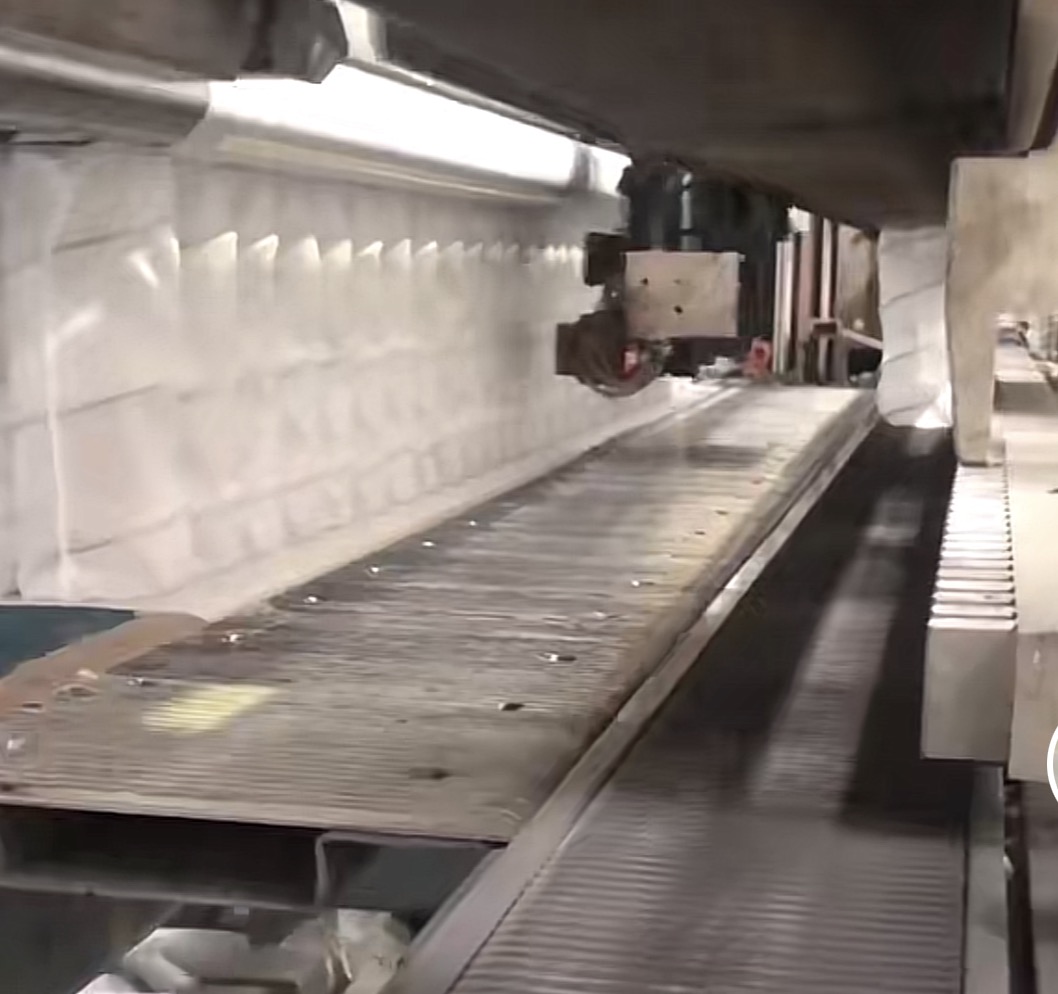 Automated mattress production line applying hot melt adhesive